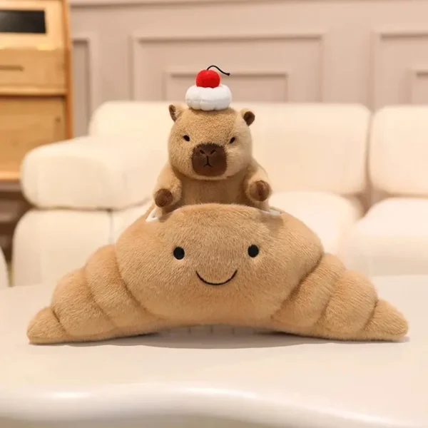 Peluche Capybara calme marron dans croissant doré kawaii avec crème et cerise.