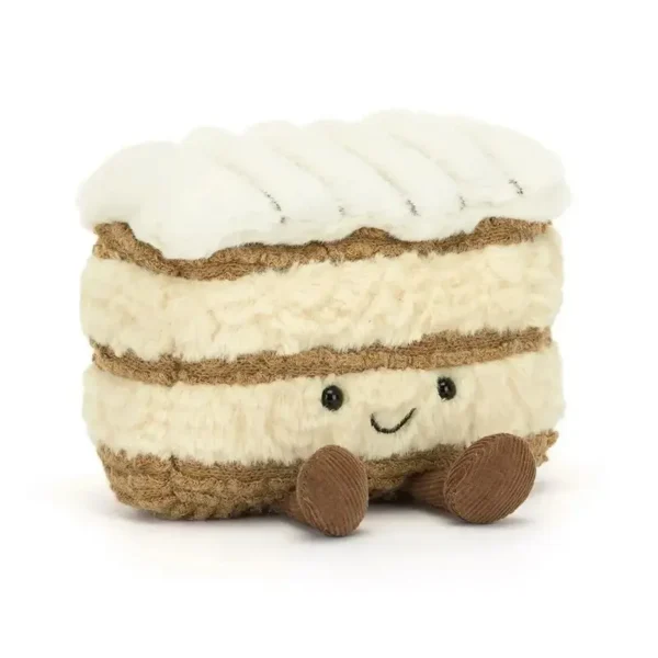 Peluche Mille Feuille gourmande assise, couches beige/marron, dessus blanc, yeux souriants.