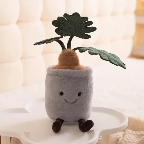Peluche Monstera kawaii design Jellycat, pot gris visage brodé, feuilles vertes dentelées.