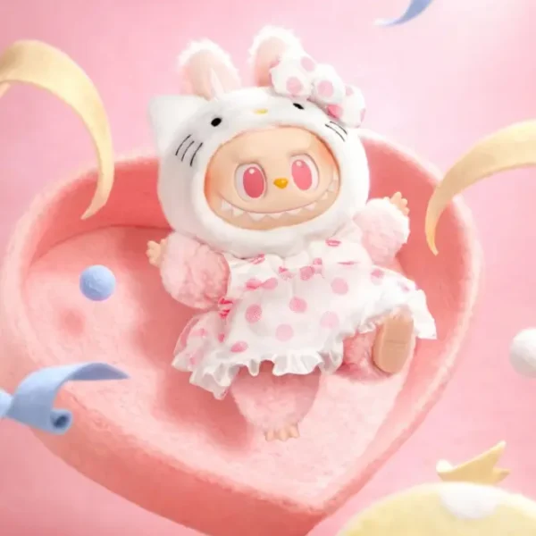 Figurine Labubu Hello Kitty en costume blanc et rose, posée sur cœur feutre et confettis.